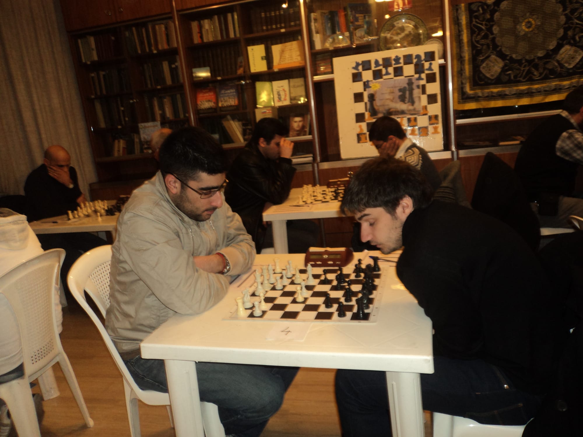 Members playing among the clubs bookshelves and demo board